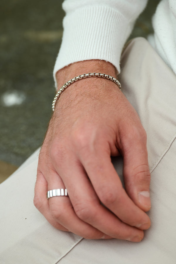 Man wearing Box chain bracelet and ridged ring in Sterling Silver with Rhodium