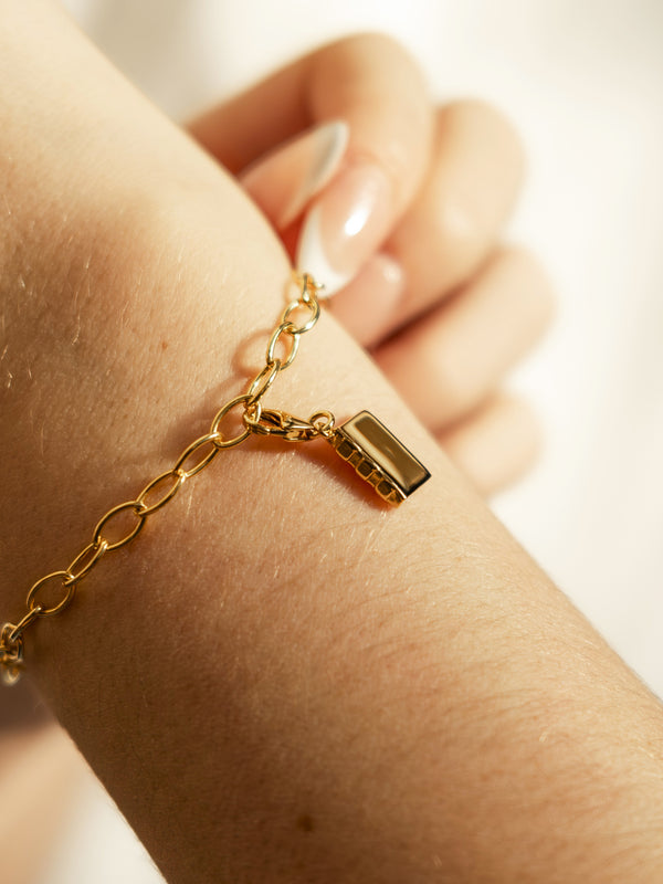 enamel book charm on bracelet in gold